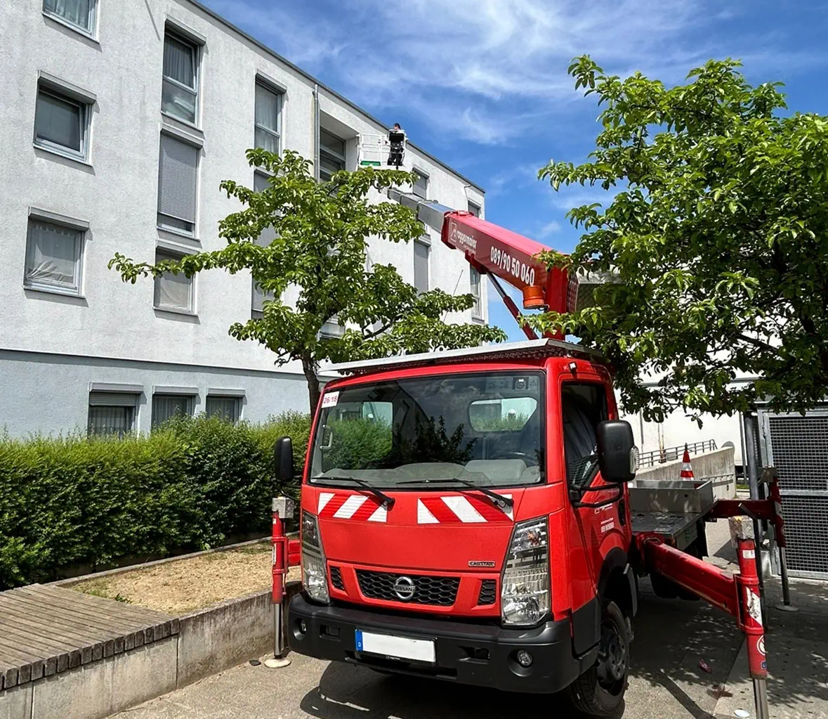 Fensterreinigung in München, Arbeiter reinigt Fenster mit Hebebühne